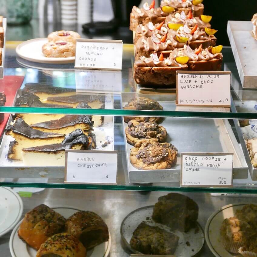 A glass display case filled with an assortment of pastries, cakes, and cookies